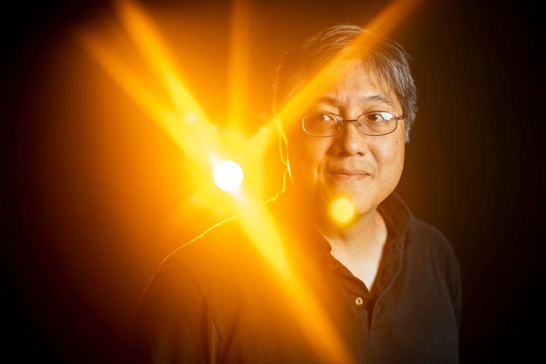 Headshot of David Bau, backlit with a bright orange light.