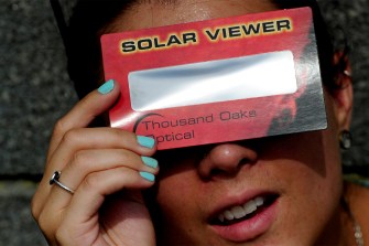 Person using a solar viewer to watch a solar eclipse.