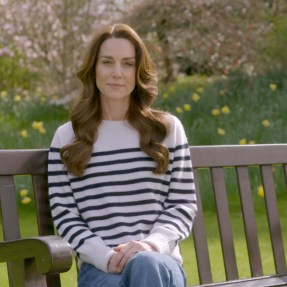 Screen capture of Kate Middleton's announcement with her sitting on a bench in a garden wearing jeans and a striped shirt.