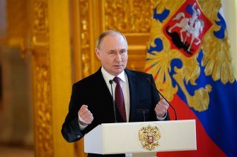 Vladimir Putin gesturing as he makes a speech.