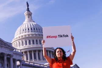 A woman holding a sign that says #KeepTikTok in front of of the Capitol in Washington D.C.