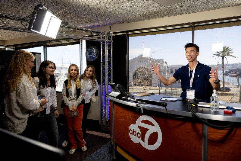 A person presents to students at a news station for Northeastern's Entrepreneurship Treks program.