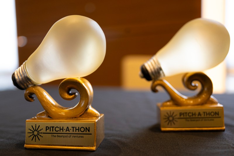 Two trophies each made of wood and a lightbulb.