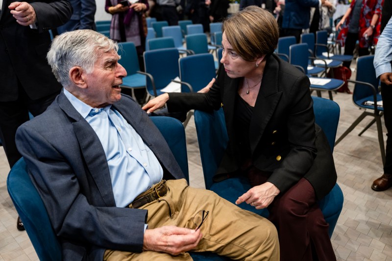 Michael Dukakis and Maura Healey greet each other.