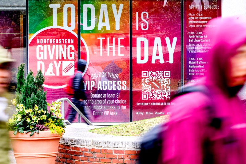 A poster on a window saying 'Today is the Day Northeastern Giving Day'.