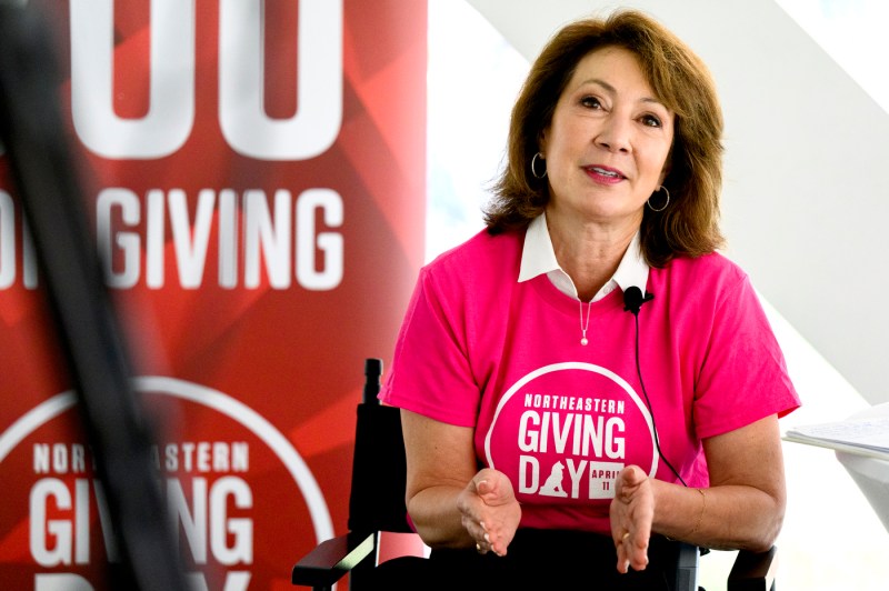 Diane Nishigaya MacGillivray wearing a pink Giving Day t-shirt with a white collared shirt underneath.