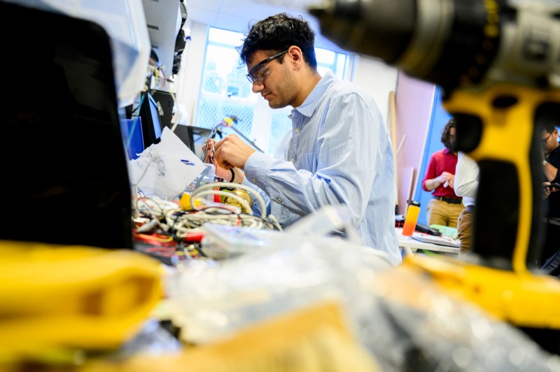 An engineering student working on a wheelchair backup sensor project.