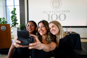 Three people taking a selfie together at the Huntington 100 Event.