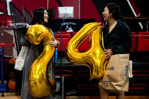 Northeastern graduates Cameron Ko and Elisa Kwon hold 2024 balloons .