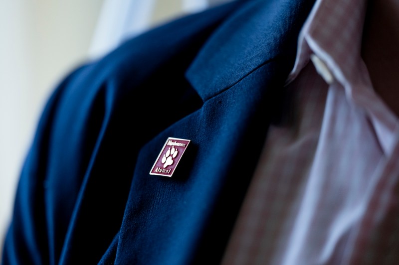 Northeaster Alumni pin on the lapels of a blue suit jacket.