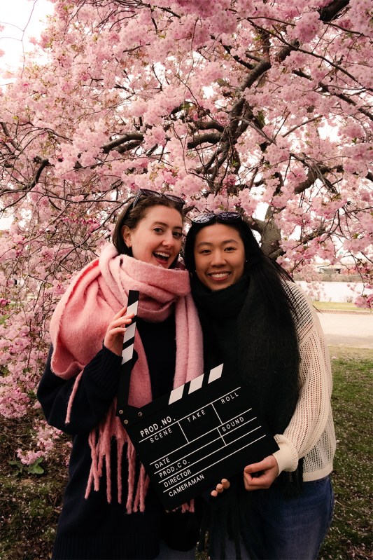 Alize Abdelhak and Kelsey Zhen posing together under cherry blossoms.