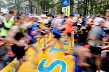 A time lapse photo of runners crossing the start line of the Boston Marathon.