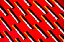 Cigarettes laid out on a red background.