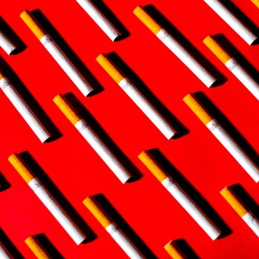 Cigarettes laid out on a red background.