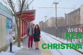 A couple stands next to the train tracks. Over the photo is the text "When Ken met Christina"