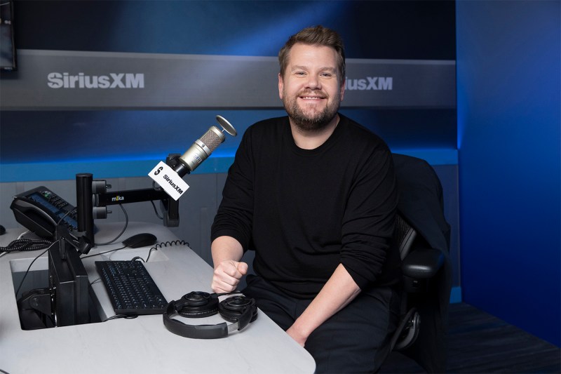 James Corden sitting in front of a microphone at the SiriusXM studies.
