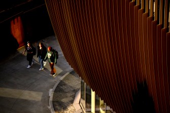 Three students walk on the Boston campus.