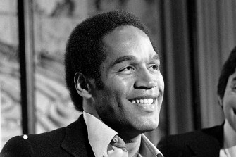 A black and white photo of O.J. Simpson smiling.