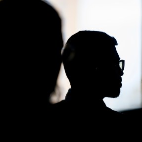 Silhouette of a person wearing glasses.