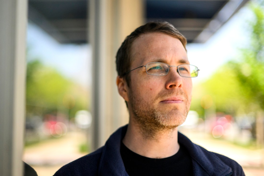 Portrait. ofMark Wells wearing glasses and stnading outside.