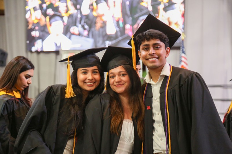 Graduates smiling for a photo at the Bouve commencement ceremony.