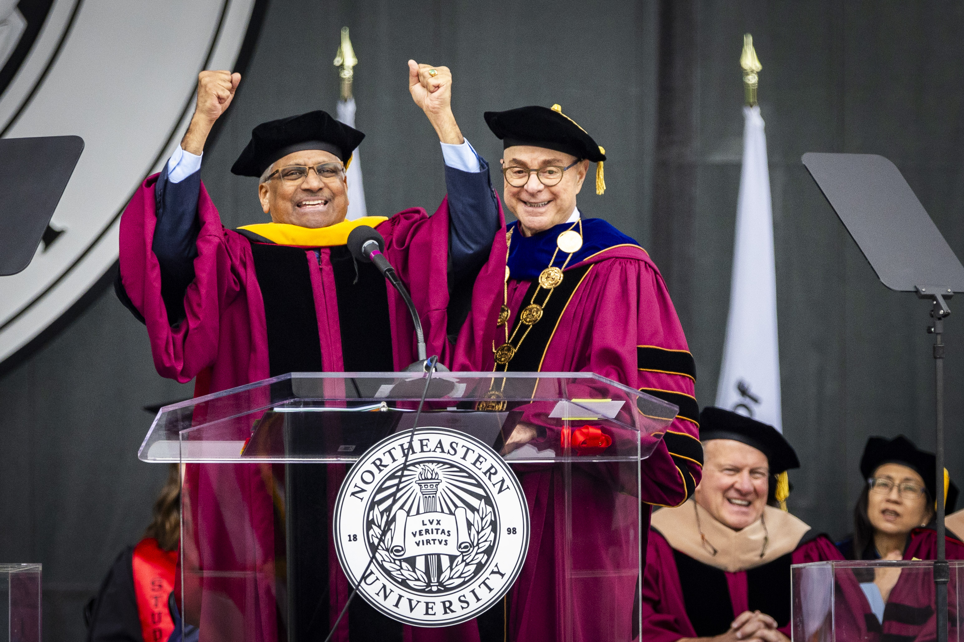 Panchanathan with his fists raised standing next to President Aoun on stage at commencement.