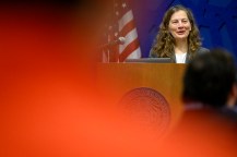 Ozlem Ergun speaking into a microphone at a podium.