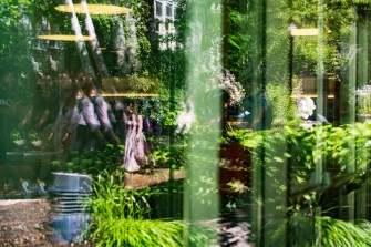 People's reflections show on a building's window.