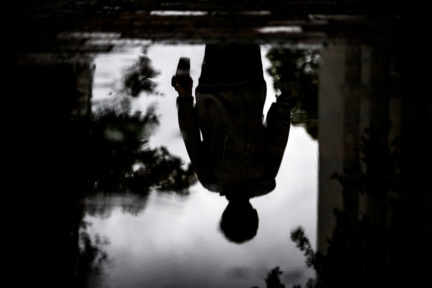 A reflection of a person in a puddle.