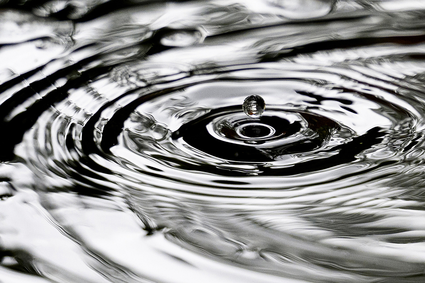 A water droplet hovering over a pool of water.