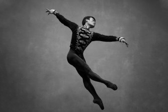 John Lam dancing, midair in black and white.