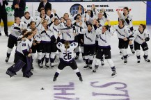 Kendall Coyne Schofield holding up a trophy in front of the Minnesota PWHL team.