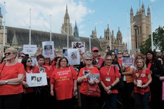 Protestors assembled at Parliament Square carrying signs and wearing red t-shirts.