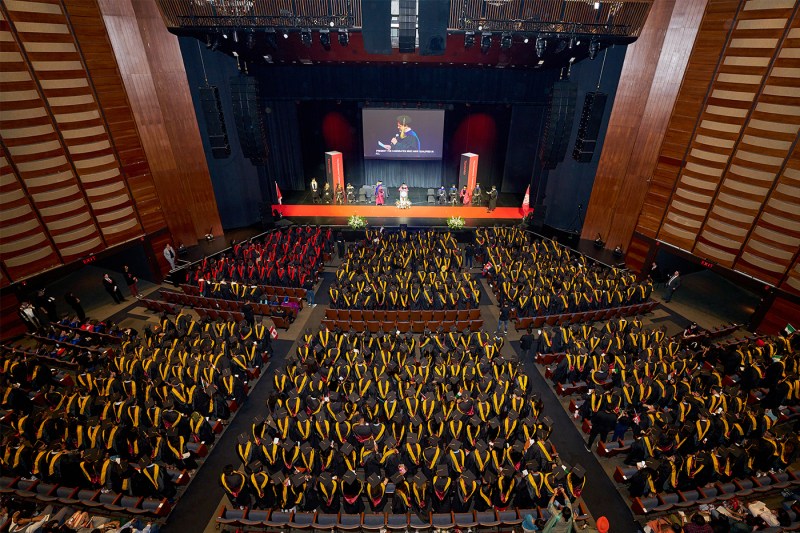 Students sitting in rows at the Toronto convocations ceremony, photographed from above.