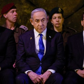 Israeli leaders sit together while wearing black suits and bright blue ties.