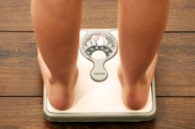 A person's feet shown standing on a weight scale.