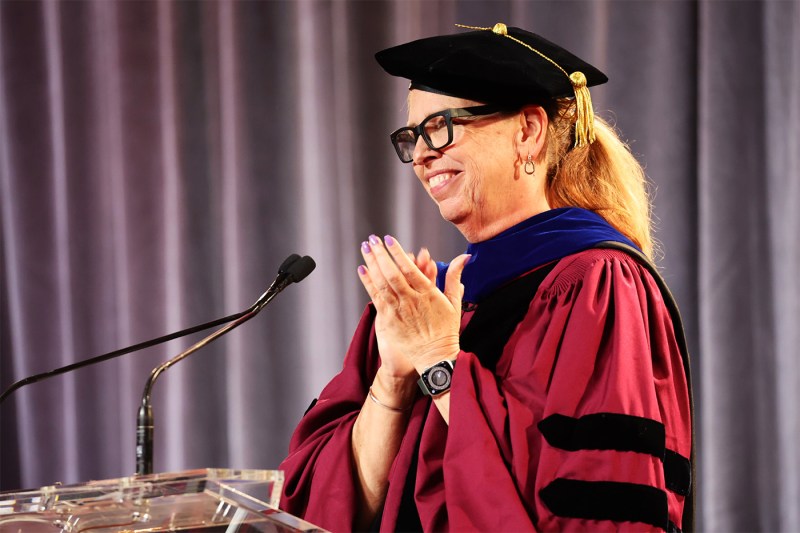 A faculty member clapping at the podium at the 2024 Vancouver Convocation.