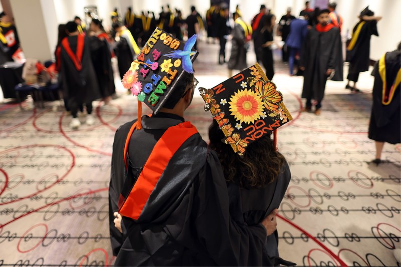 Two graduates with decorated caps at the 2024 Vancouver Convocation.