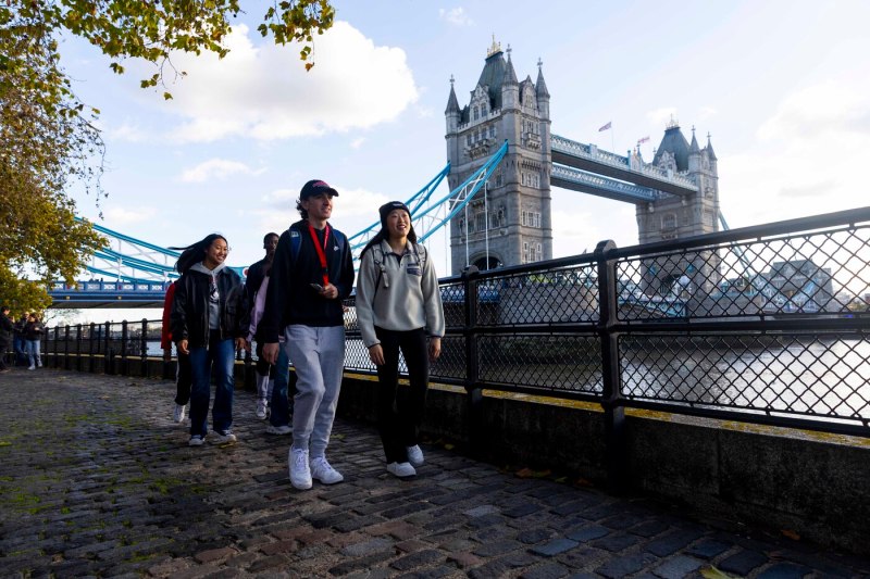 Four Northeastern students walking in front of The London Tower bridge.