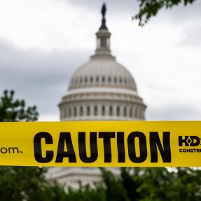 A photo of the Capitol with yellow caution tape outside of it.