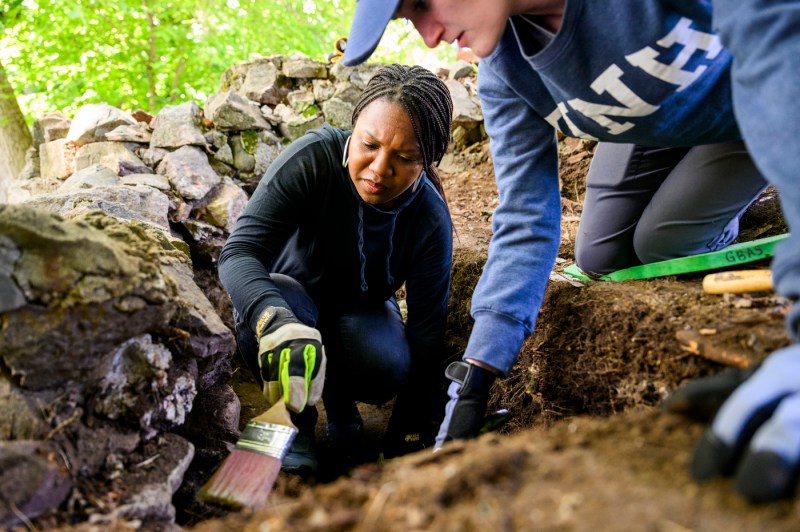 Kabria Baumgartner and a UNH researcher digging.