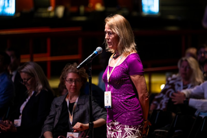 A speaker wearing a pink shirt speaking at the Climatech 2024 Conference.