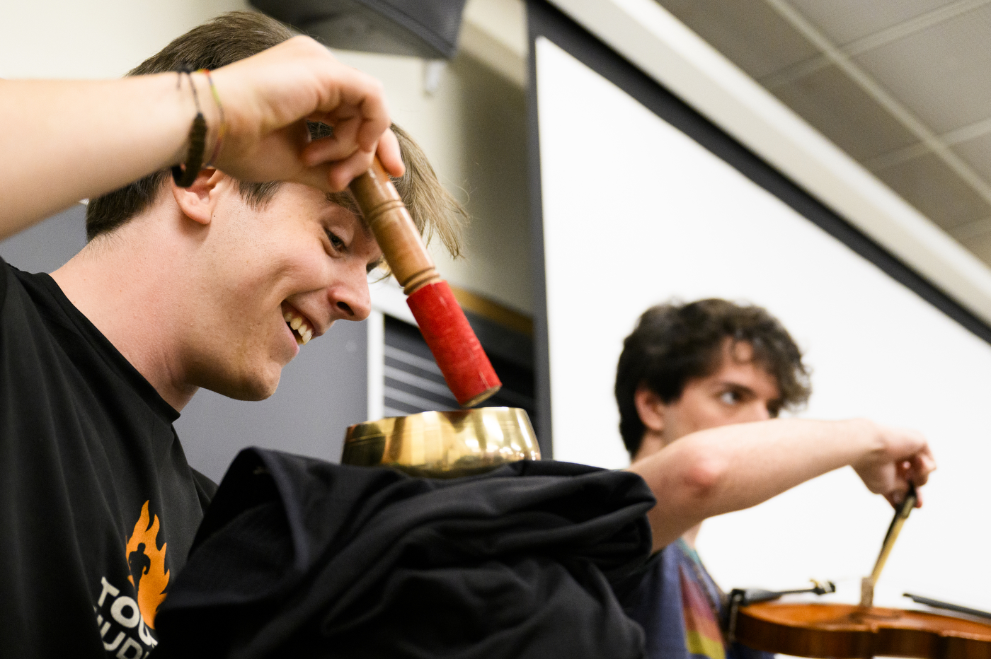 A student smiles while using a historical music technology technique.