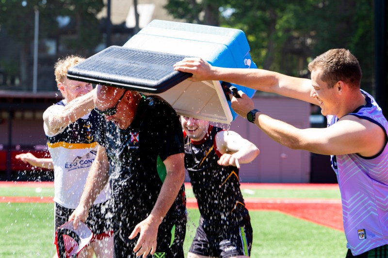 Gaelic football team members dumping a cooler of ice on top of Conor Deegan.