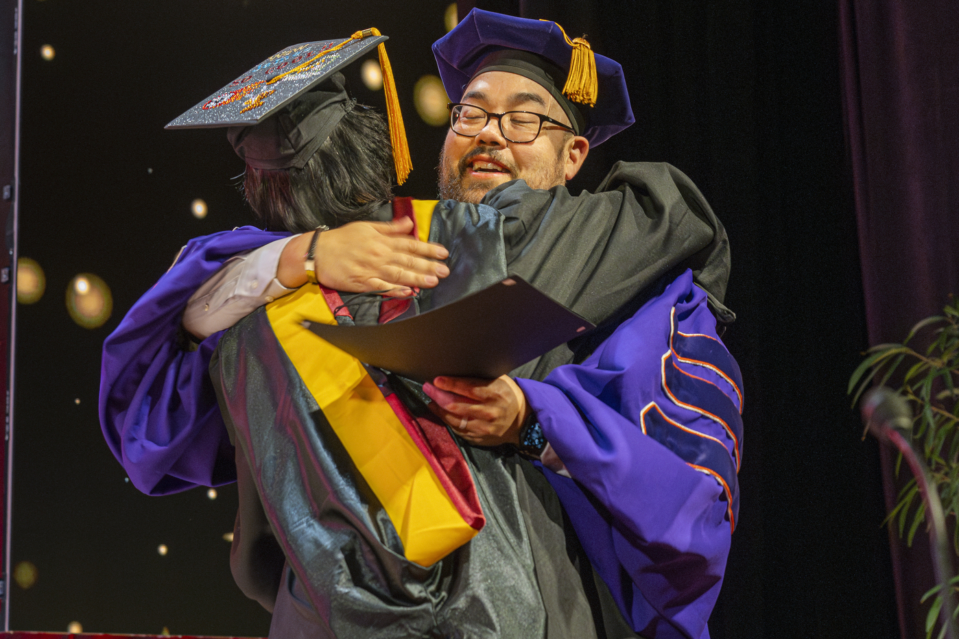 Two graduates hugging.