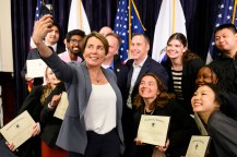 Governor Maura Healey takes a selfie with staff members and students.