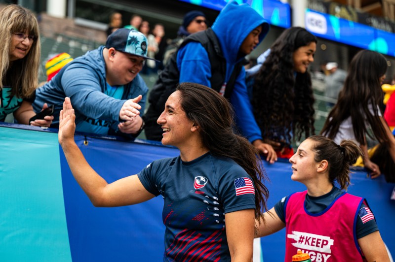 Sarah Levy clapping hands with fans on the sidelines.