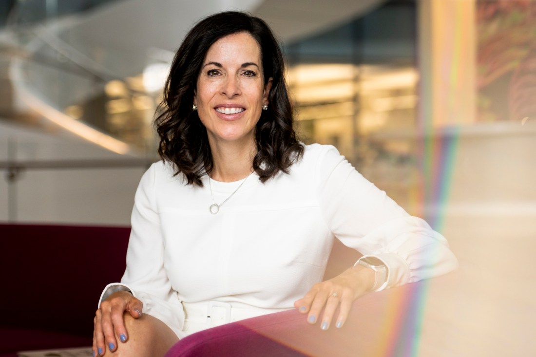 Portrait of Kristen Lee sitting in a chair wearing a white long sleeve shirt.