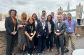 Twelve people of Northeastern's Shark Tank program pose for a picture in front of the London Bridge.