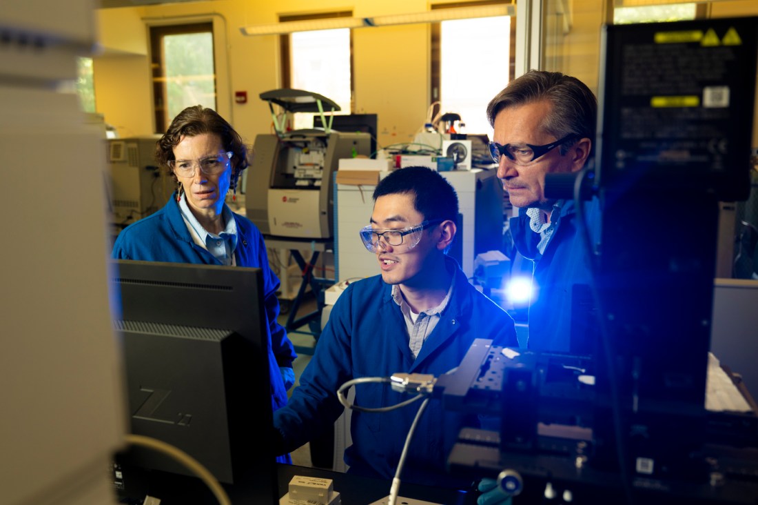 Alexander Ivanov, Anne-Lise Marie, and Yunnan Gao gathered around a computer screen in a lab.